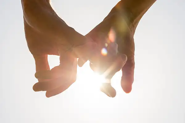 Couple holding hands in the sunlight