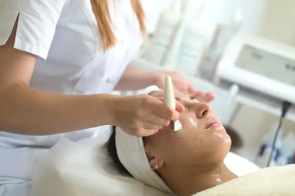 Woman having facial cleansing done at a beauty spa
